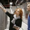 Selective focus view of serious businesswoman and businessmen collaborating and examining server in high tech server room