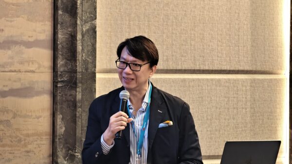 專業男士在演講台上發言 男士在會議中用麥克風發言,背景為會議室牆壁.