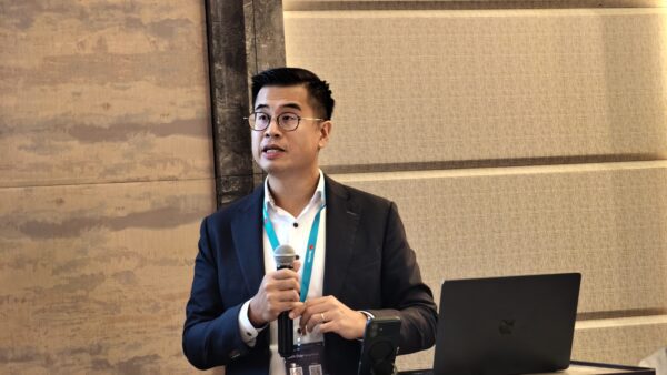 富邦銀行AI應用獲獎演講者 演講者在會議中發言,背景為會議室和筆記本電腦.