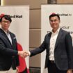兩位商業代表握手，背景有Red Hat與富邦銀行標誌.