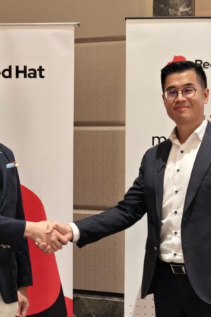兩位商業代表握手，背景有Red Hat與富邦銀行標誌.