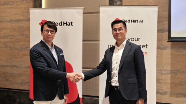 富邦銀行與Red Hat合作簽約儀式 兩位商業代表握手,背景有Red Hat與富邦銀行標誌.