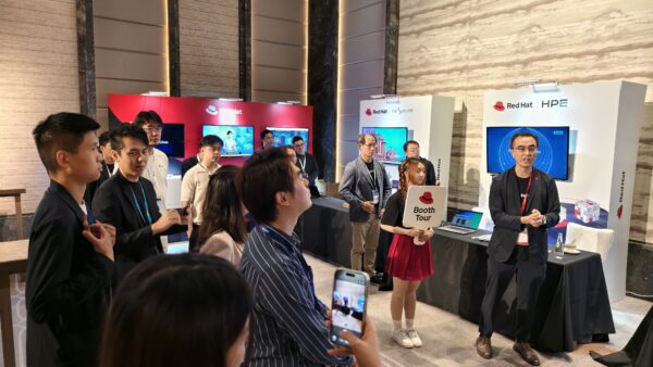 Red Hat 創新獎展覽現場 參觀者在Red Hat展台前聽取講解,展示AI應用與金融科技創新.