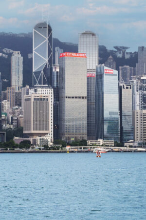 香港天際線與維多利亞港的都市與海景,沿岸高樓大廈耸立,遠景山脈成背景.