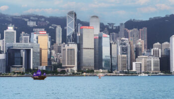 香港天際線與維多利亞港的都市與海景,沿岸高樓大廈耸立,遠景山脈成背景.