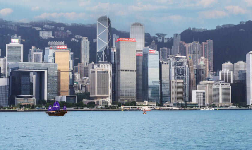 香港天際線與維多利亞港的都市與海景,沿岸高樓大廈耸立,遠景山脈成背景.