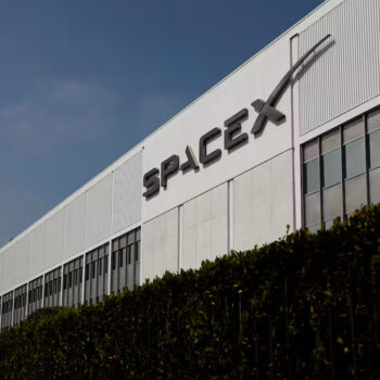SPACEX 設施外觀，清晰可見的公司標誌與現代化工廠建築.
